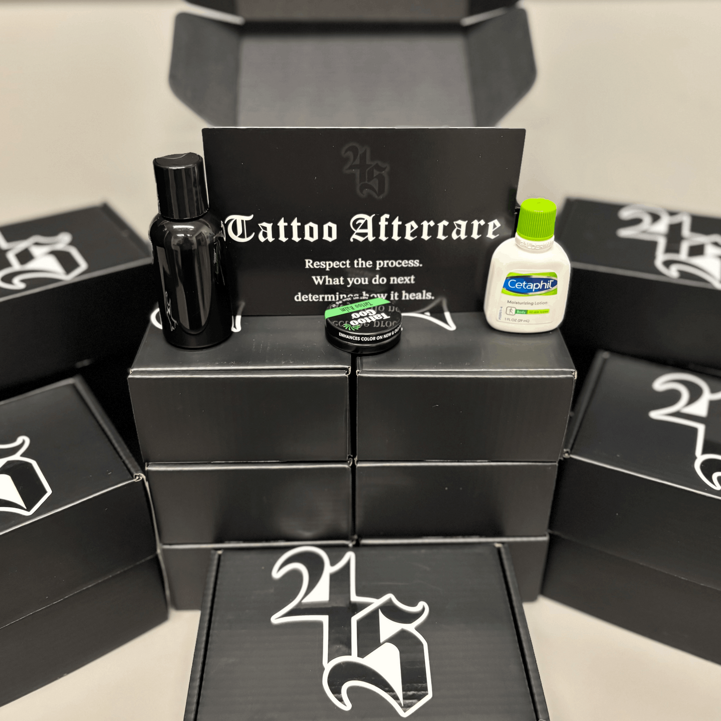 Tattoo aftercare products on a stack of black boxes with 4S logo.
